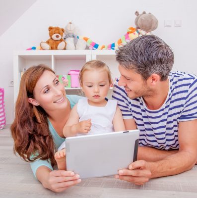 family playing with tablet showing photos and reading e-book